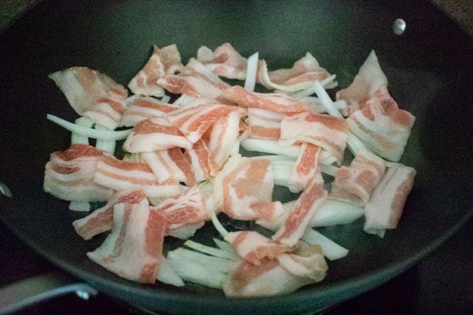 sliced pork belly and onion in wok