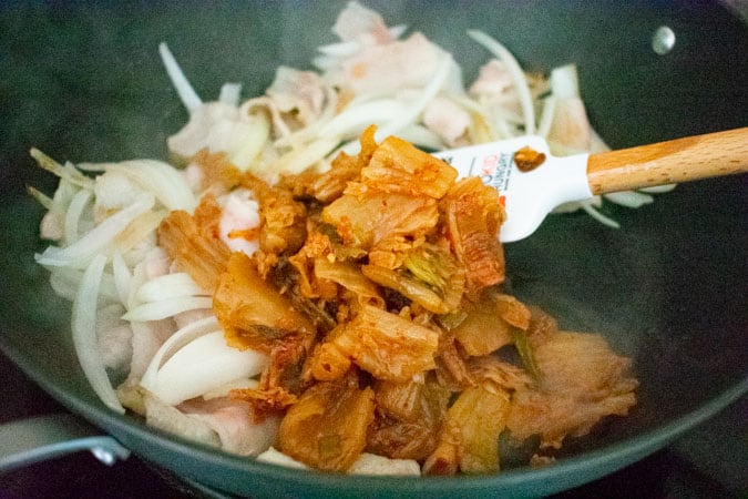 sliced pork belly and kimchi in wok