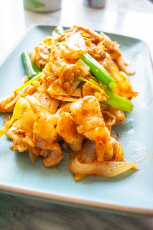 kimchi pork belly stir fry on blue plate