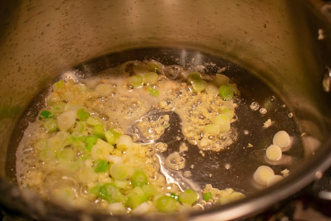 Morimoto inspired manila clams start with garlic in pot