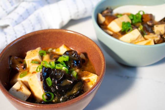 easy vegan mapo tofu in blue and brown bowls