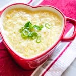 egg drop soup in a mini red heart shaped ceramic dish on a red and white striped towel