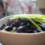 Steaming bowl of vegetarian jia jiang myeon with garnish of cucumber strips