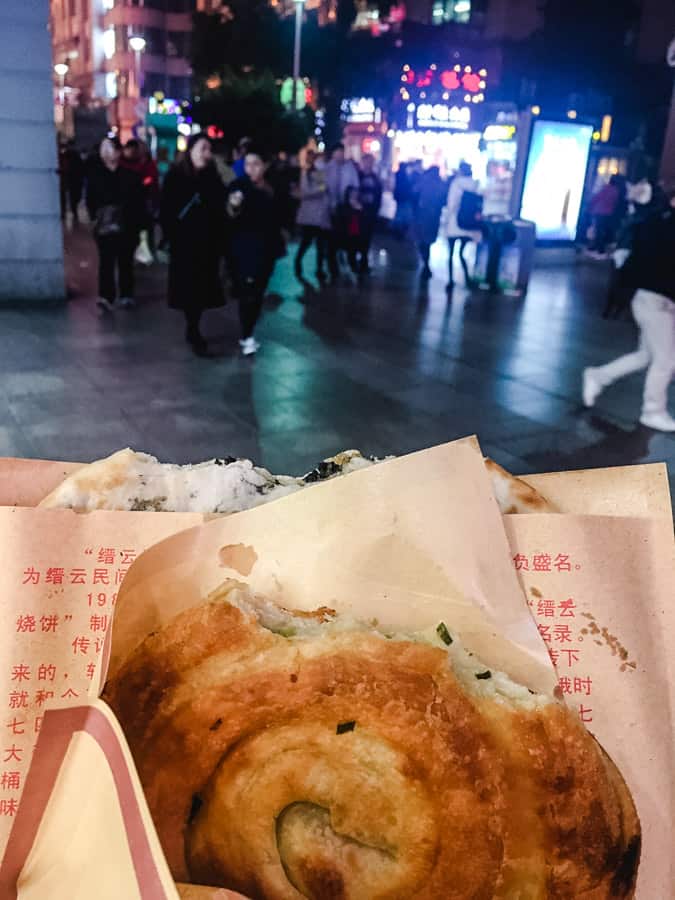 Green onion pancake in a brown paper wrapper on Nanjing Road in Shanghai, China