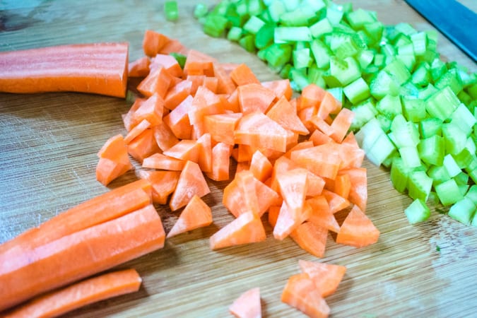 diced carrots and celery on a wooden cutting board