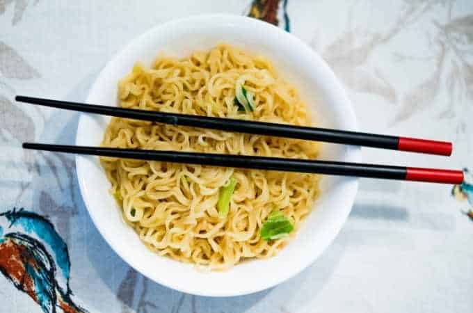 ramen noodles in a white bowl with black chopsticks