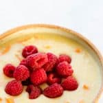 close up shot of vegan millet porridge with raspberries and sweet potatoes in a bowl
