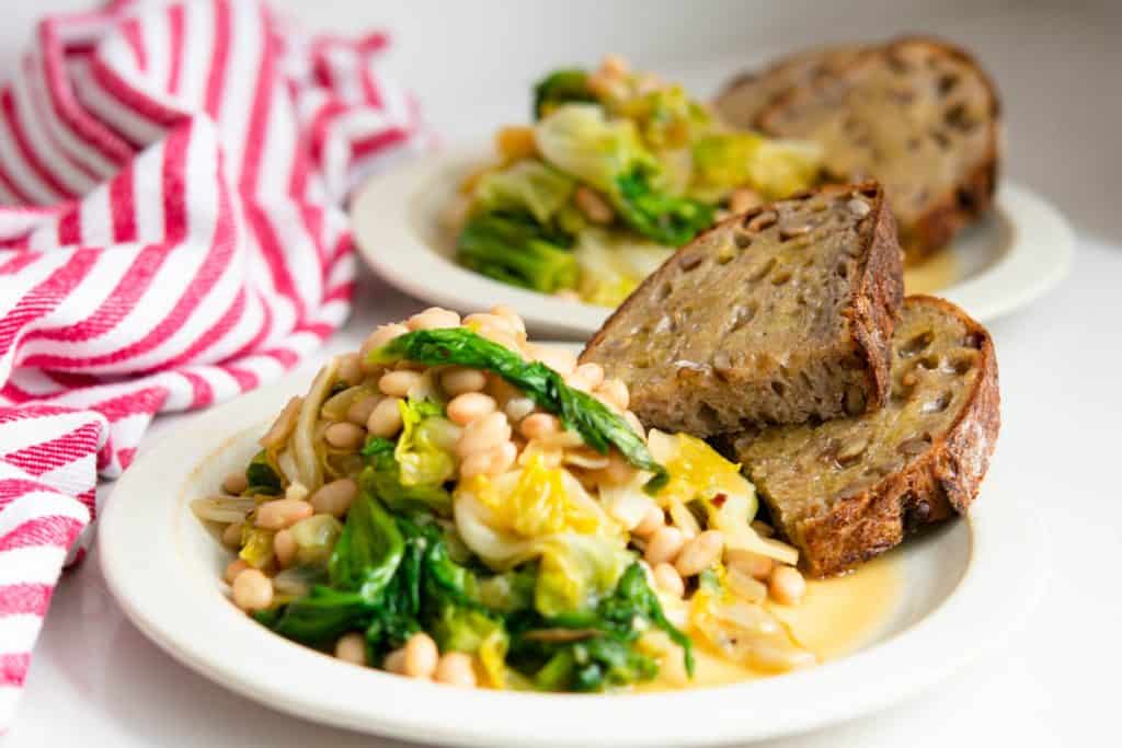 2 plates of Beans and greens with sourdough toast