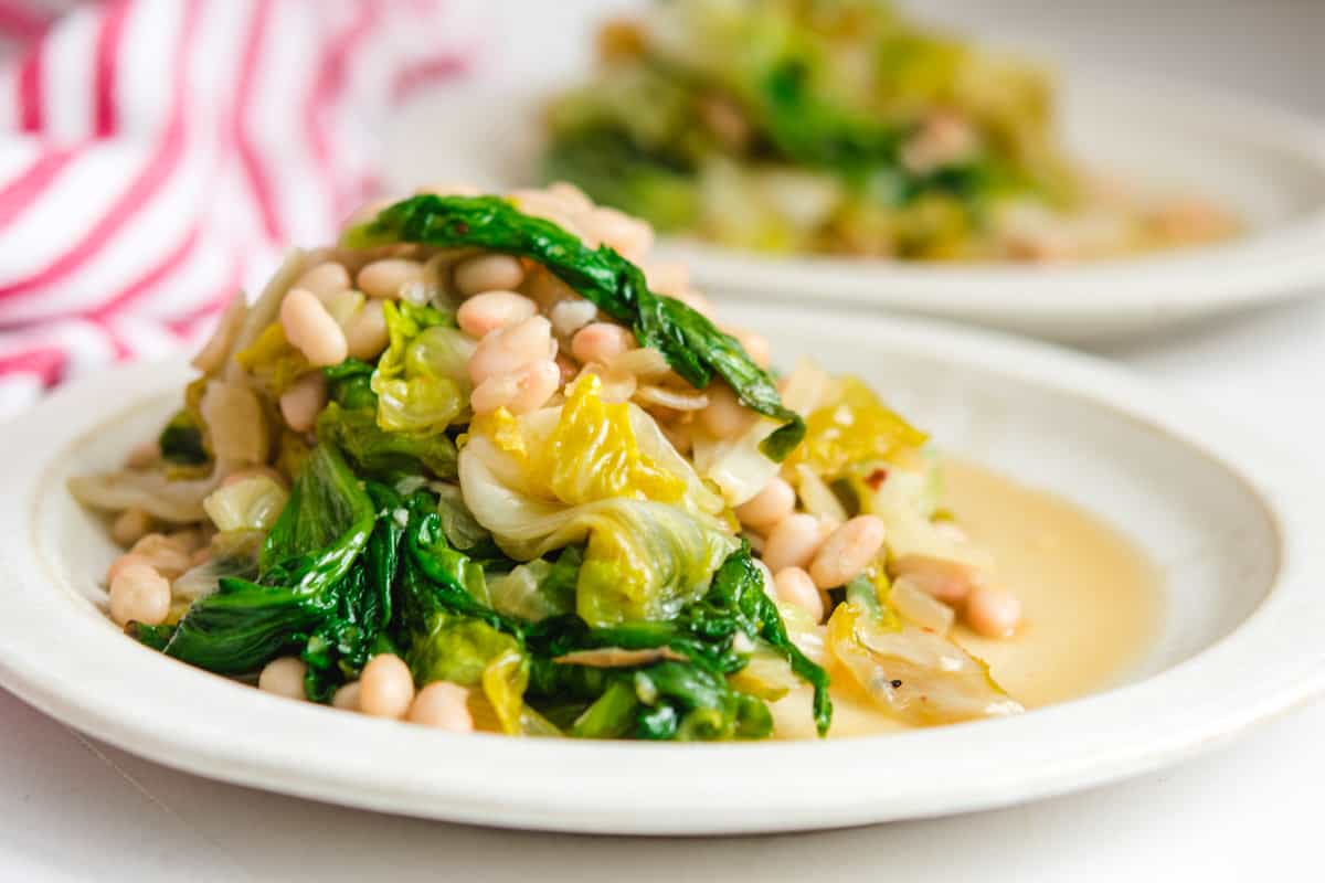 a pile of vegan beans and greens on a white plate