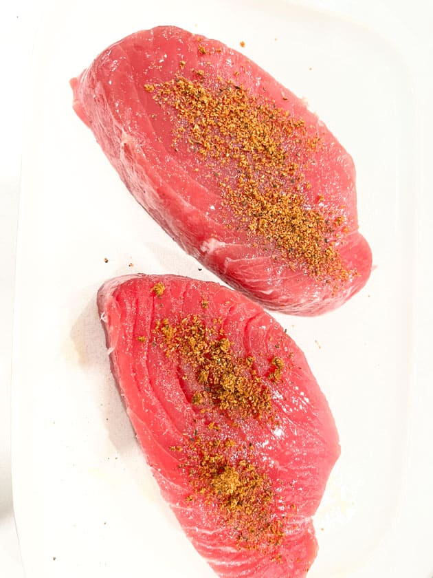2 tuna steaks with cajun seasoning spooned on top
