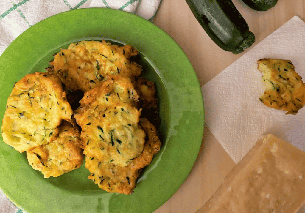 fluffy zucchini fritters on a green plate