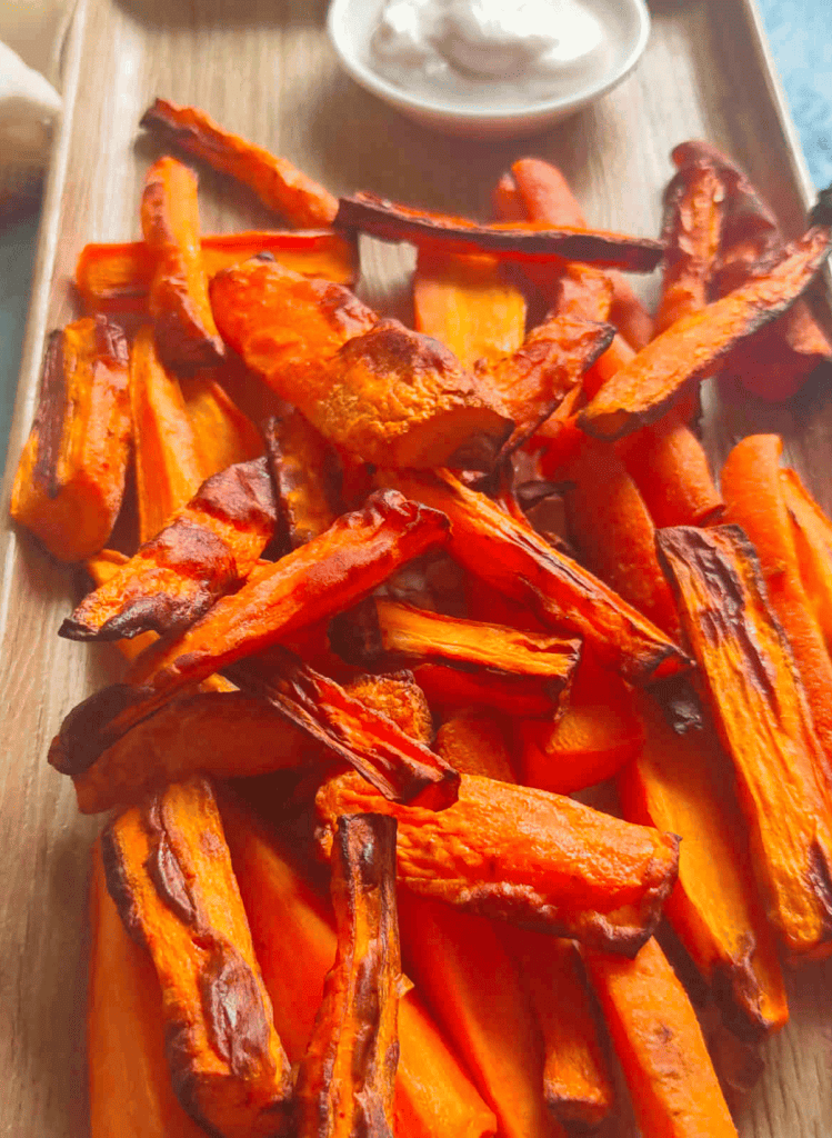 air fryer carrot fries on a rectangular wooden cutting board