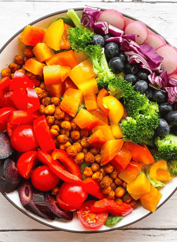 rainbow salad with each vegetable in rows in a white bowl