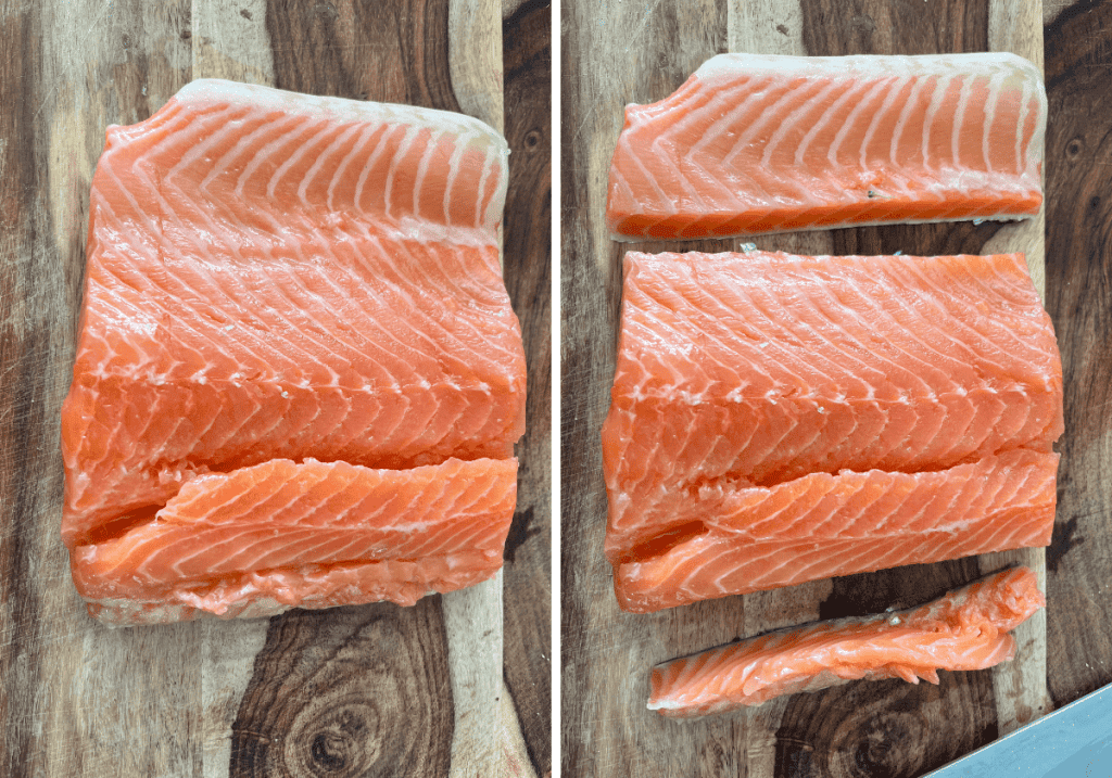 Fillet of salmon being trimmed on a wooden cutting board.