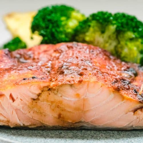 Hawaiian salmon on a gray plate with broccoli florets behind it.