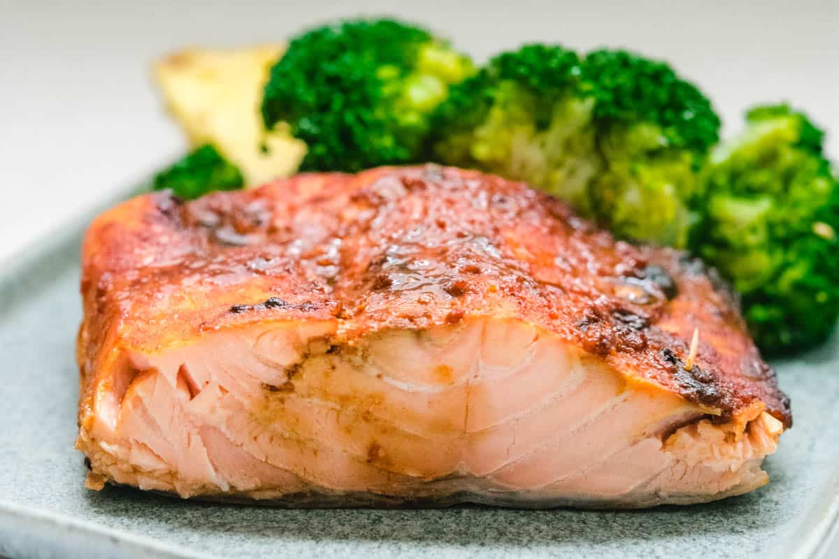 Hawaiian salmon on a gray plate with broccoli florets behind it.