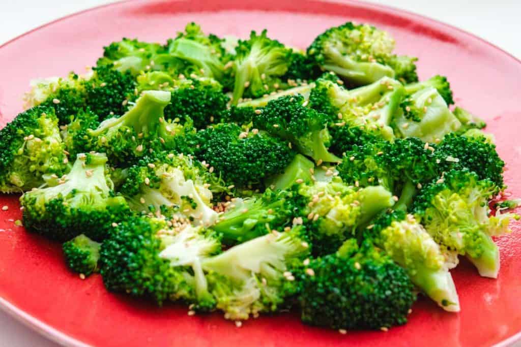 Korean broccoli salad on a red plate.