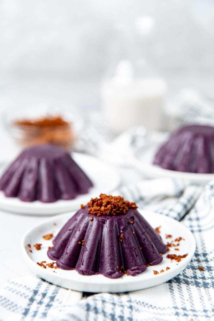 Ube Halaya Jam shaped in jelly molds on white round plates with blue checkered napkins