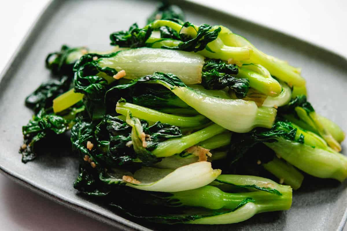 stir fried baby book choy on a grey rectangular plate