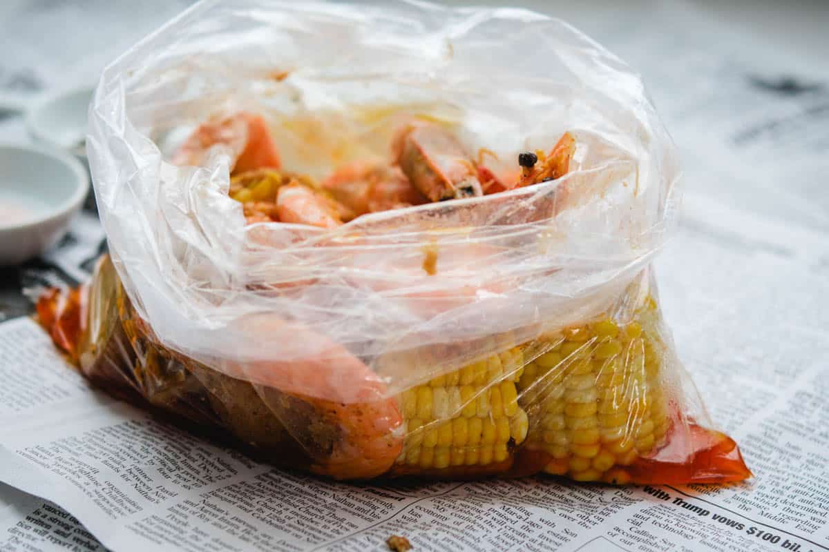 head on shrimp with boiling crab sauce in a plastic bag