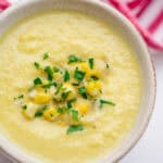 Japanese corn potage in a white mug with a red striped napkin in the background