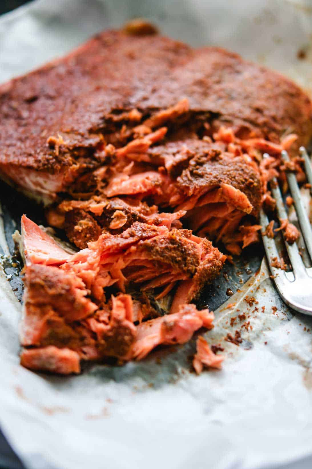 sockeye salmon talkes with a fork on white parchment paper