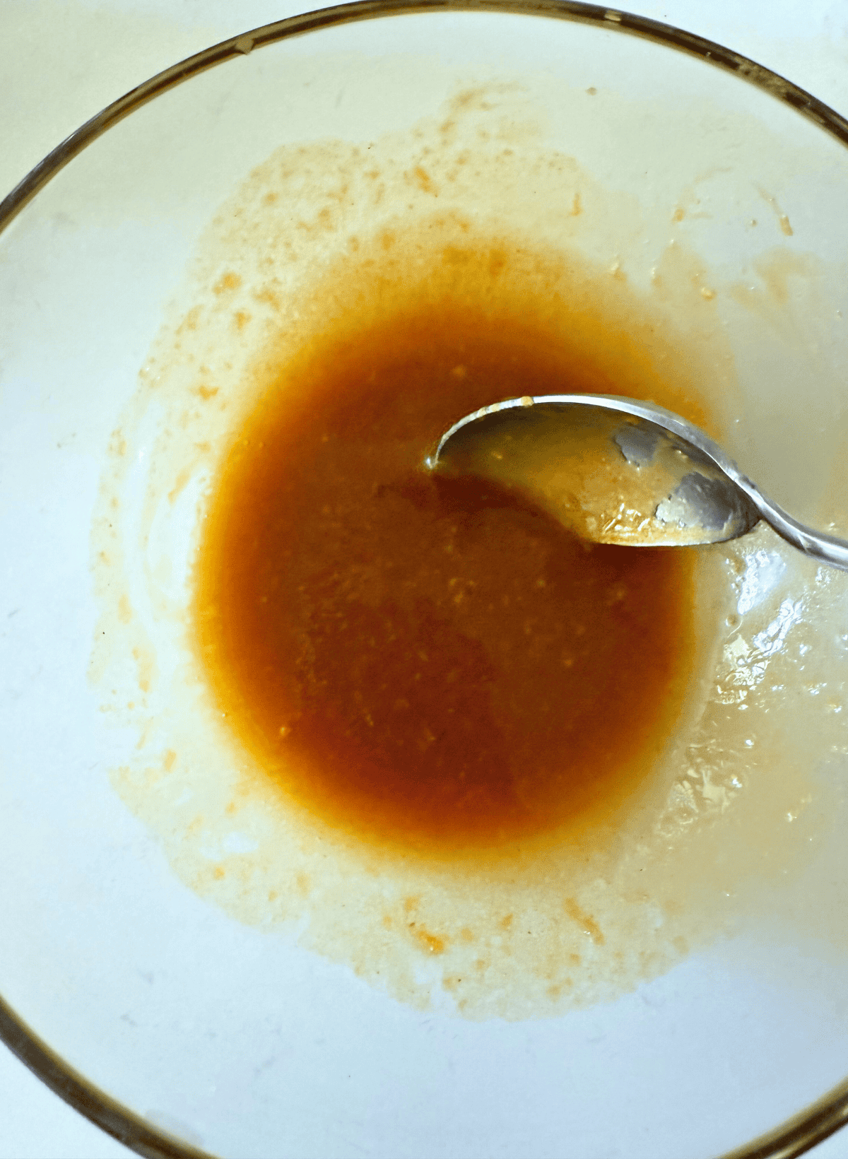 sauce for glazed king salmon in a glass bowl with a spoon