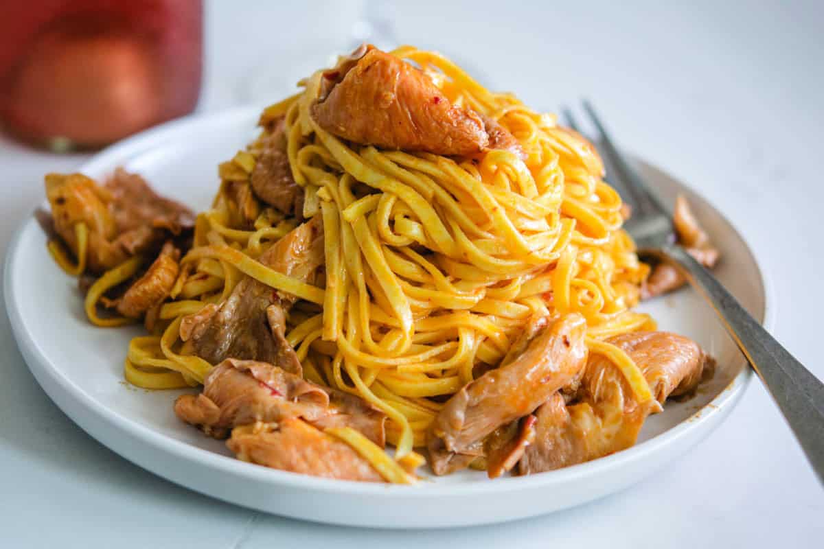 فطر المحار الوردي على طبق أبيض مستدير مع شوكة